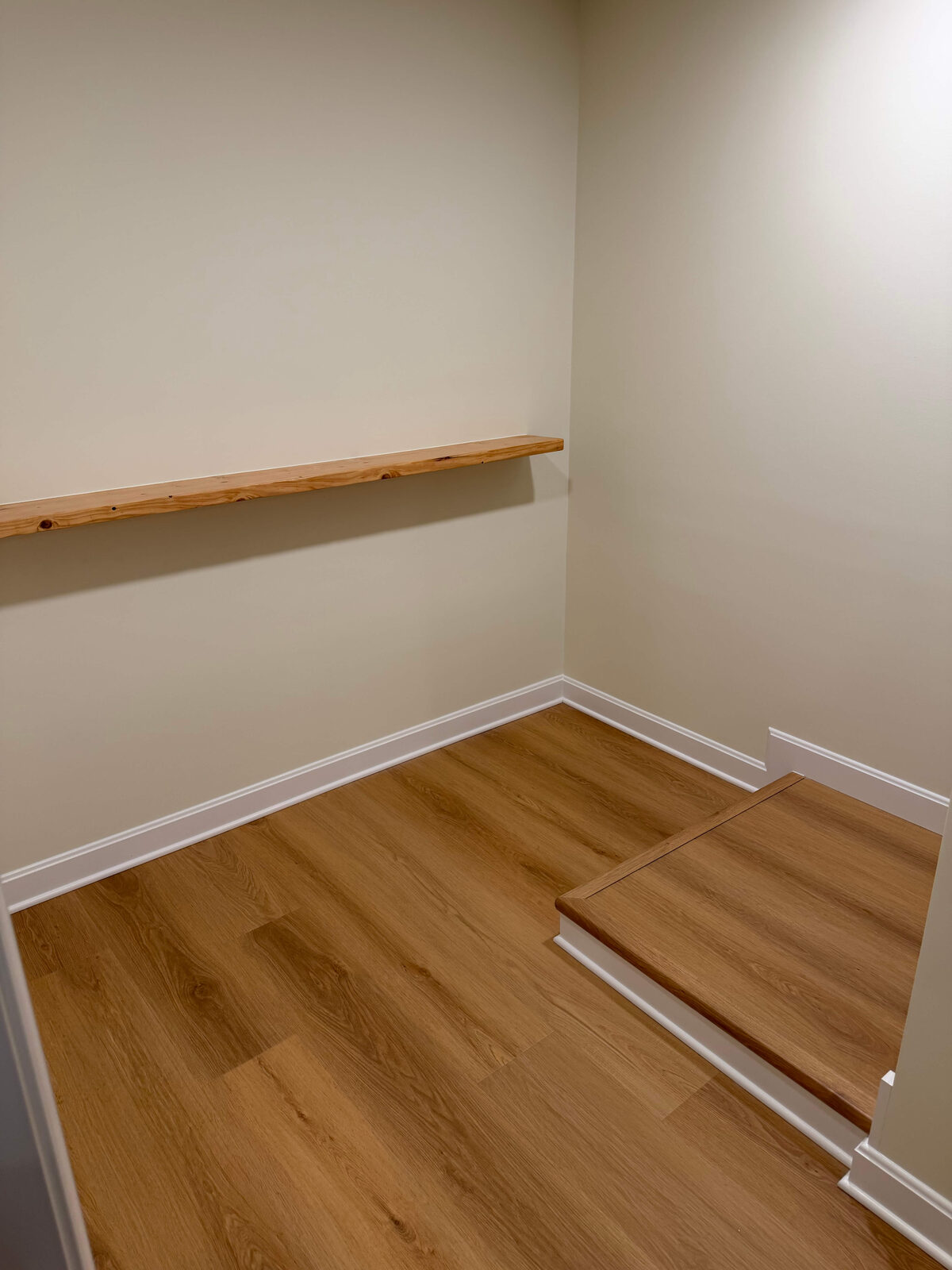 Basement closet with live-edge floating shelf and LVP flooring