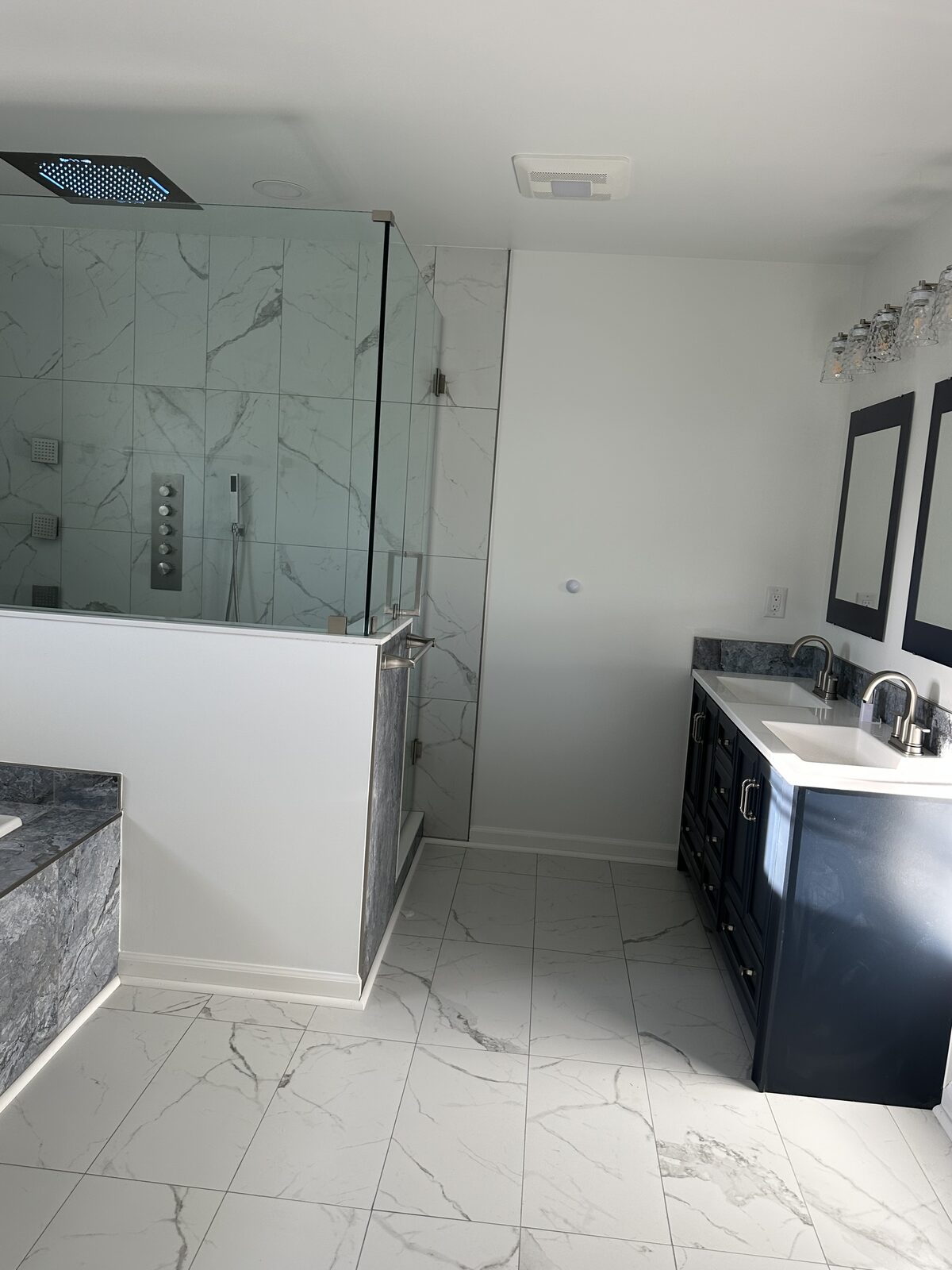 Marble tile floor with navy vanity and walk-in shower