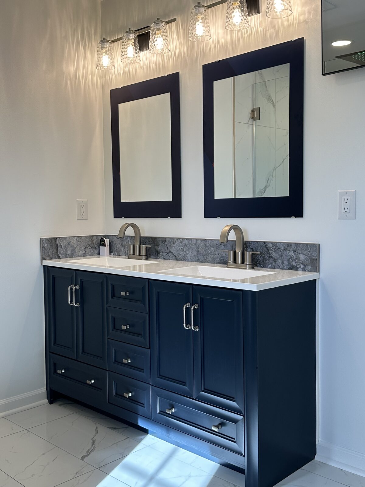 Custom double vanity with marble backsplash and brushed nickel fixtures